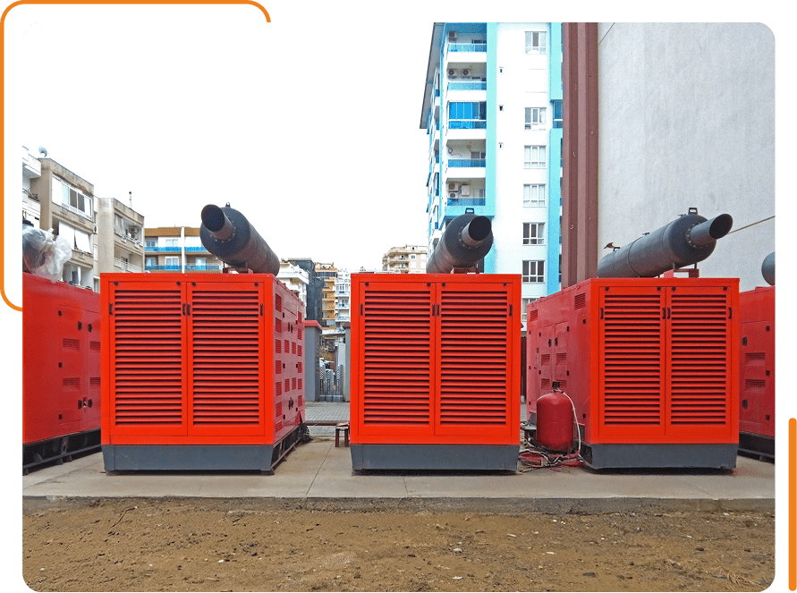 Three red industrial generators outside buildings.